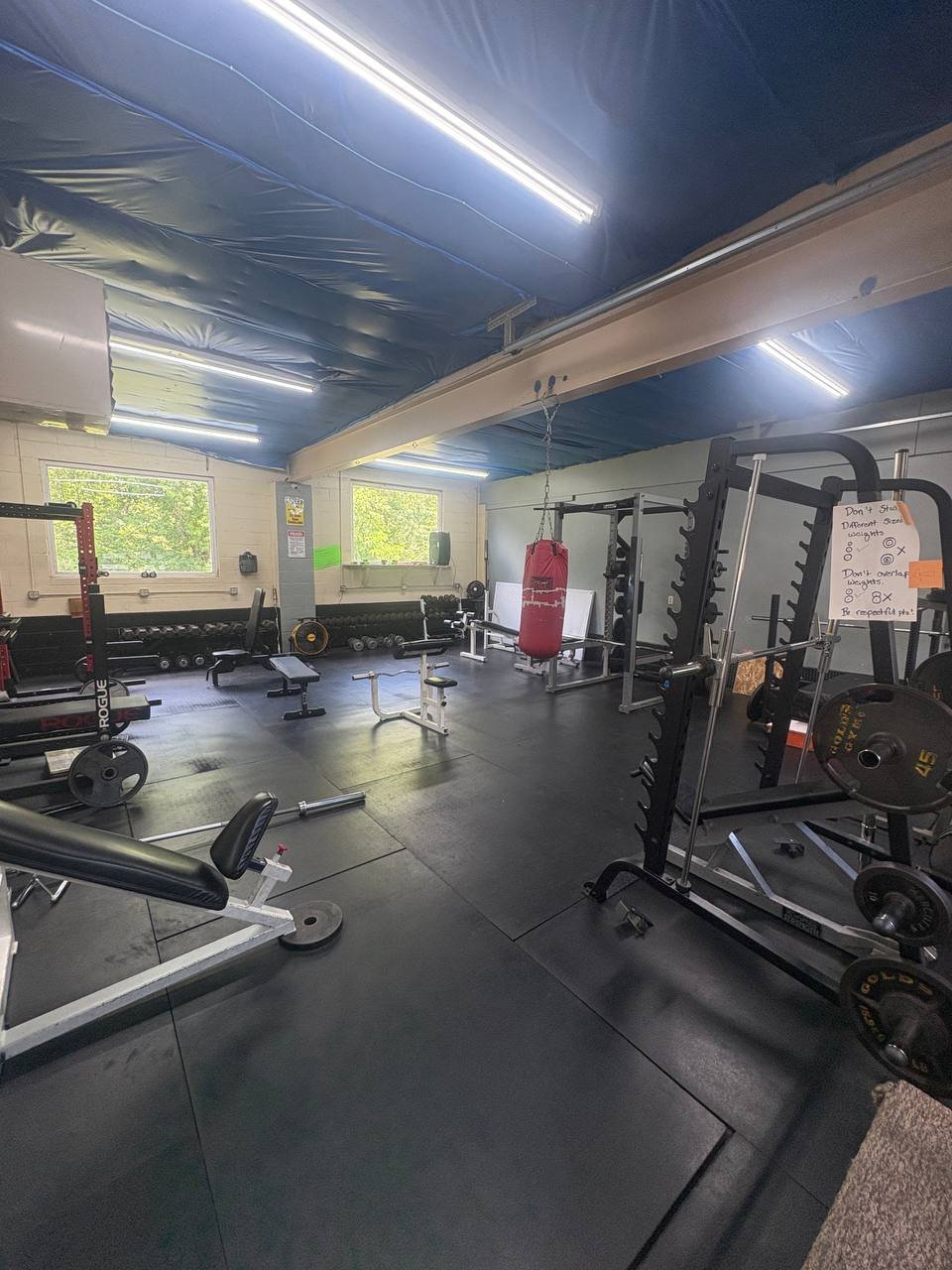 The free-weight room — power racks, benches, plates, and heavy bag