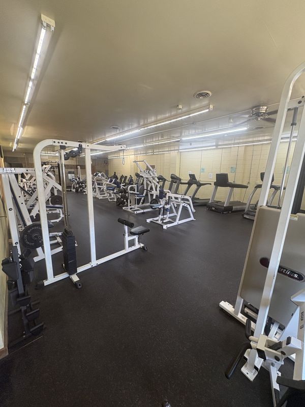 Row of strength training machines along the wall